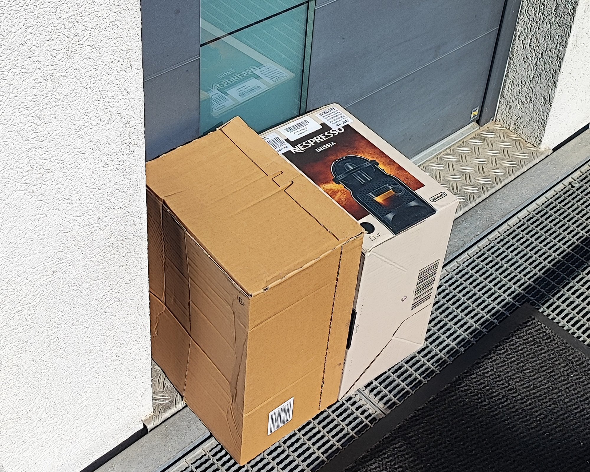 Pakete vor der Tür, darunter ein Nespresso-Karton