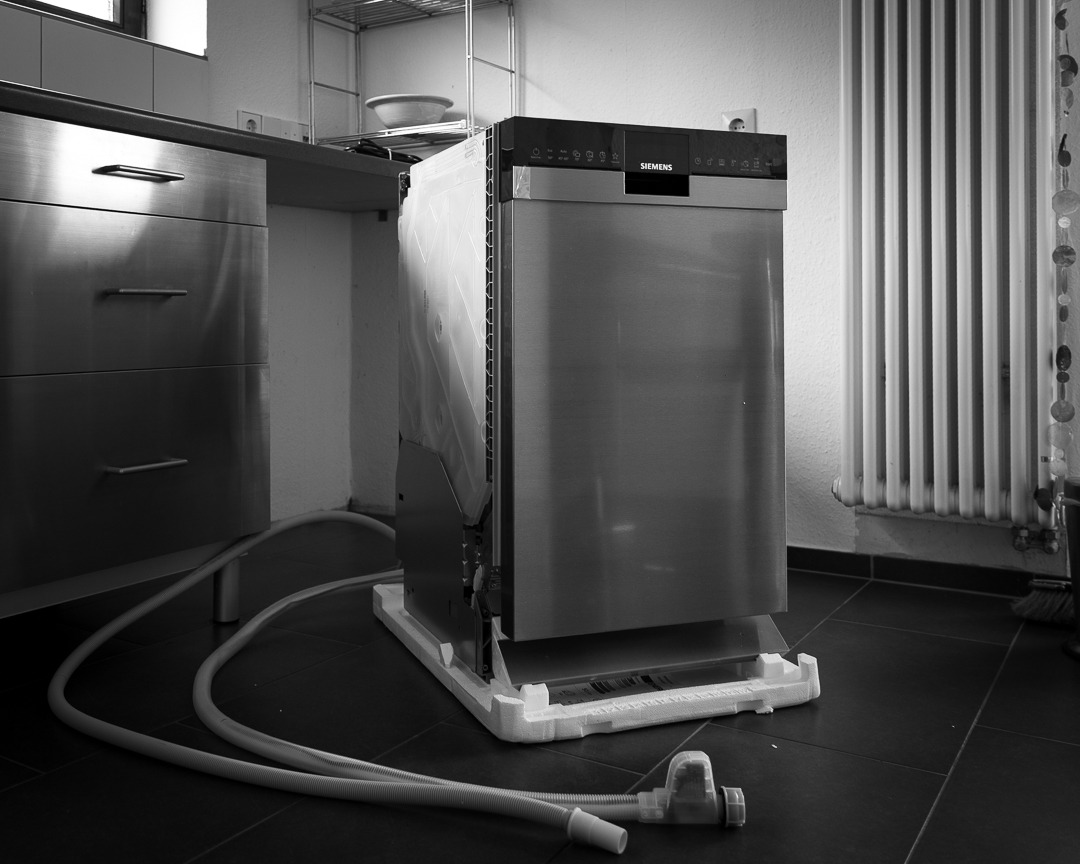 Neue Spülmaschine vor dem Einbau unter der Arbeitsplatte in der Küche der Ferienwohnung Wahlwies, Schwarzweißfoto
