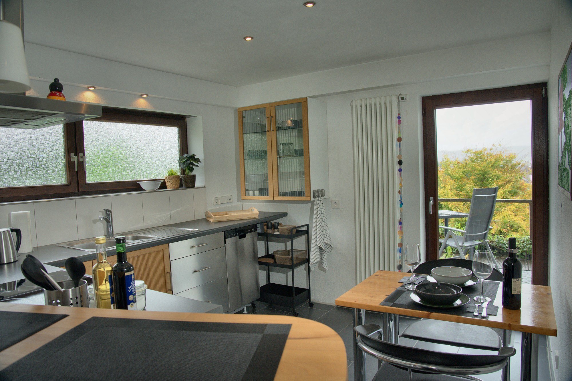Küche der Ferienwohnung mit Terrassentür und Glasschrank
